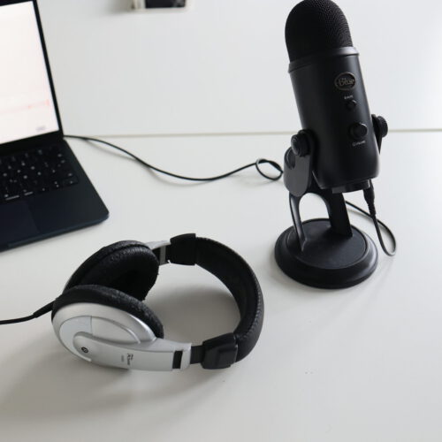 Ein Mikrofon, Kopfhörer Und Ein Laptop Auf Einem Tisch Drapiert.